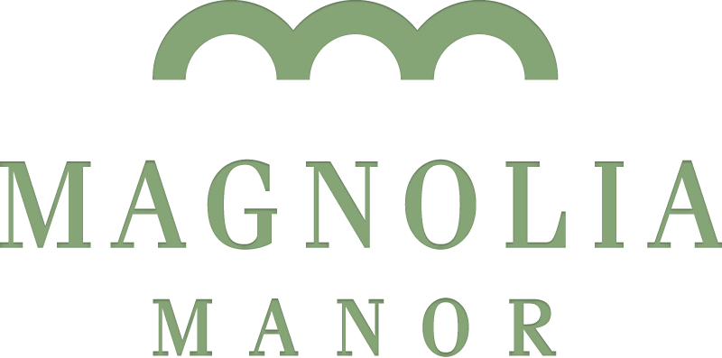 A green sign with the words " magnolia manor ".
